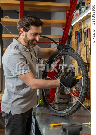 Mechanic in black gloves inspecting wheel 126388959