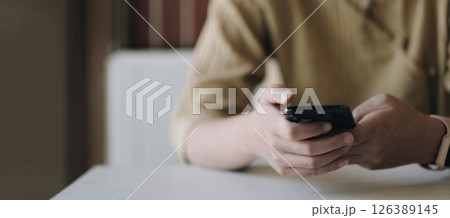 Mockup image of a woman holding mobile phone with blank black screen in cafe Mockup image of a woman holding mobile phone with blank black screen in cafe 126389145