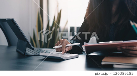 Close up Business woman using calculator and laptop for do math finance on wooden desk in office and business working background, tax, accounting, statistics and analytic research concept Close up Business woman using calculator and laptop for do math finance on wooden desk in office and business working background, tax, accounting, statistics and analytic research concept 126389183