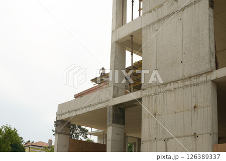 Multistory Concrete Building Under Construction With Worker Multistory Concrete Building Under Construction With Worker 126389337