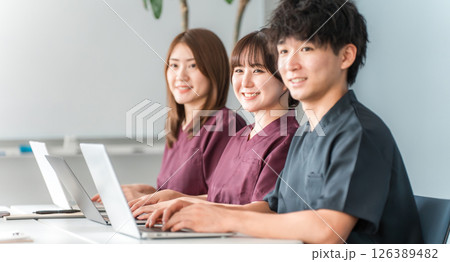 医療,カンファレンス・勉強会・セミナー・研修・研修を受けるスクラブ姿の男女医療スタッフ 126389482