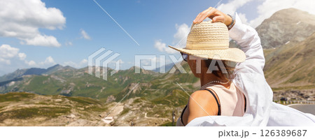 Young adult woman explore scenic alpine stunning mountain peak landscape view sunny day. Female happy girl person enjoy alps high road pass panorama.  travel adventure tourism trip tour vacation. 126389687