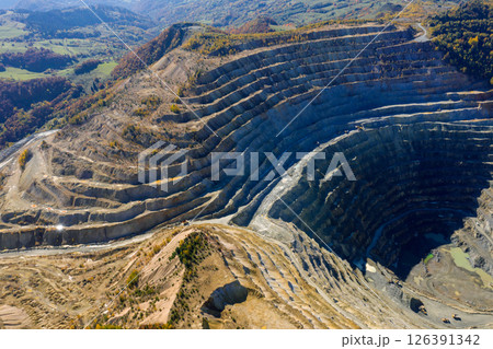 Flying above an open pit mine, copper excavation in Rosia Poieni, Romania. Aerial view Flying above an open pit mine, copper excavation in Rosia Poieni, Romania. Aerial view 126391342