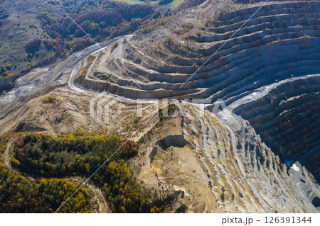 Flying above an open pit mine, copper excavation in Rosia Poieni, Romania. Aerial view Flying above an open pit mine, copper excavation in Rosia Poieni, Romania. Aerial view 126391344
