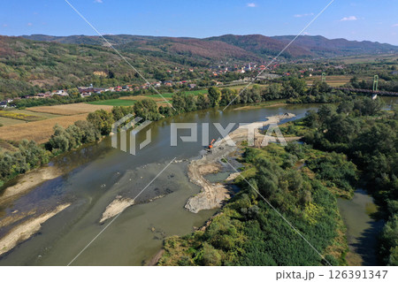 Aerial view of backhoes digging sand and gravel with shovels from the river 126391347
