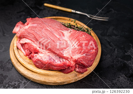 Raw Silverside Round beef meat piece , fresh bottom round on wooden board. black background. Top view Raw Silverside Round beef meat piece , fresh bottom round on wooden board. black background. Top view 126392230