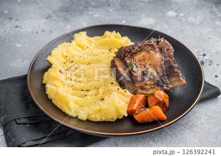 Slow cooked Beef short ribs, perfectly cooked and glazed with a rich barbecue sauce. grey background. top view Slow cooked Beef short ribs, perfectly cooked and glazed with a rich barbecue sauce. grey background. top view 126392241