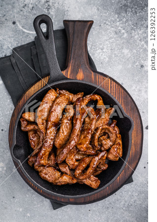 Delicious glazed teriyaki beef in a skillet. grey background. top view Delicious glazed teriyaki beef in a skillet. grey background. top view 126392253
