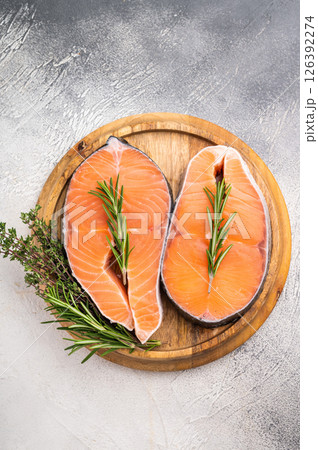 Premium salmon loin steak, expertly cut and displayed, perfect for culinary creations. Elevate your dishes with this delicious seafood option. grey background. top view 126392274