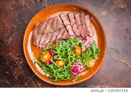 Grilled Australian Oyster Top blade steak with salad on a plate. brown background. top view Grilled Australian Oyster Top blade steak with salad on a plate. brown background. top view 126392358