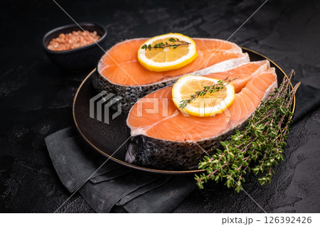 High-quality salmon portion, ready to be transformed into a gourmet dish. A versatile ingredient for both traditional and modern recipes. black background. top view High-quality salmon portion, ready to be transformed into a gourmet dish. A versatile ingredient for both traditional and modern recipes. black background. top view 126392426