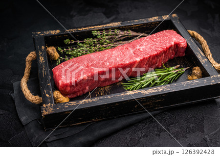 Fresh wagyu brisket cut, beautifully presented with intricate marbling. A must-have for steak enthusiasts looking to elevate their dining options. black background. top view 126392428