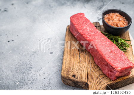 Juicy raw Kobe style beef, renowned for its exceptional flavor and tenderness. Perfect for preparing mouthwatering steaks or sashimi. grey background. top view 126392450