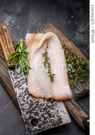 Freshly cut cod fish fillet, highlighting its mild taste and versatility in various dishes. black background. top view Freshly cut cod fish fillet, highlighting its mild taste and versatility in various dishes. black background. top view 126392453