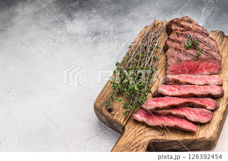 Flavorsome beef Denver shoulder tender, grilled in BBQ to juicy perfection, served with fresh herbs. grey background. top view Flavorsome beef Denver shoulder tender, grilled in BBQ to juicy perfection, served with fresh herbs. grey background. top view 126392454