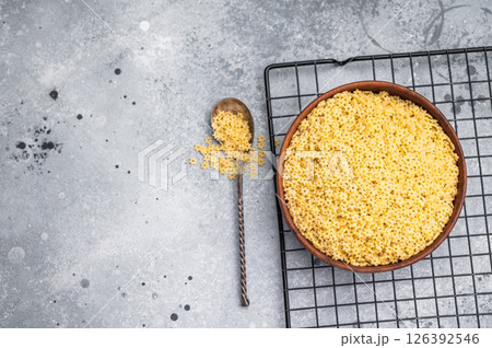 Raw stelline pasta, uncooked Italian soup Noodle in a bowl. grey background. top view Raw stelline pasta, uncooked Italian soup Noodle in a bowl. grey background. top view 126392546