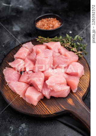 Sliced turkey fillet cubes, diced poultry breast meat. black background. top view Sliced turkey fillet cubes, diced poultry breast meat. black background. top view 126392572