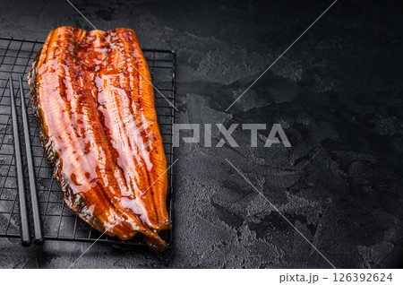 Japanese unagi eel, grilled fish fillet of eel. black background. top view Japanese unagi eel, grilled fish fillet of eel. black background. top view 126392624