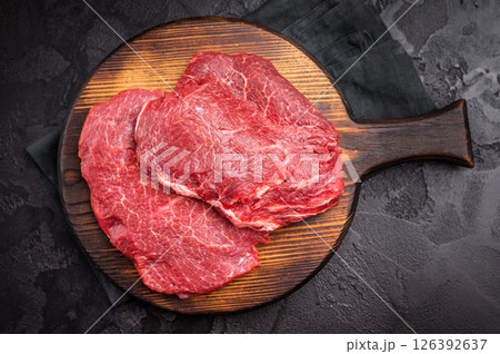 Butcher board with raw beef cheeks, uncooked meat. black background. top view 126392637