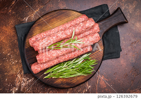 Fresh raw beef and lamb meat kebabs sausages on wooden board. brown background. top view 126392679