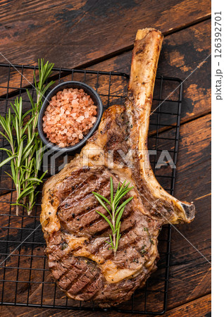 Grilled Tomahawk beef steak, cooked rib eye with bone. wooden background. top view Grilled Tomahawk beef steak, cooked rib eye with bone. wooden background. top view 126392701