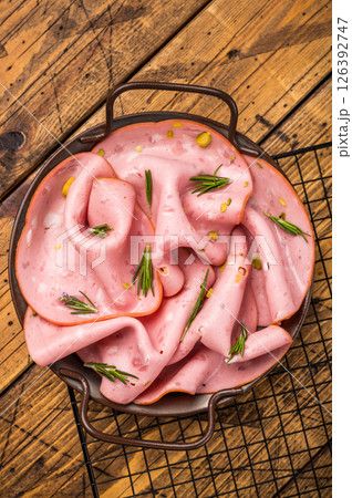 Mortadella sausage slices with pistachios for sandwiches in steel tray. wooden background. top view 126392747