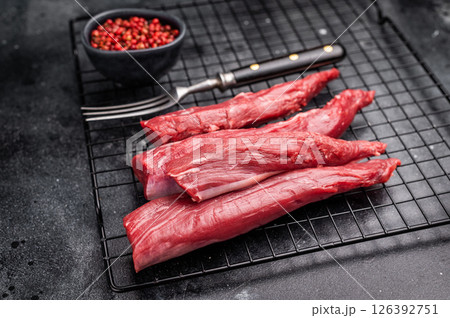 Raw lamb tenderloin fillet meat, fresh mutton. black background. top view Raw lamb tenderloin fillet meat, fresh mutton. black background. top view 126392751