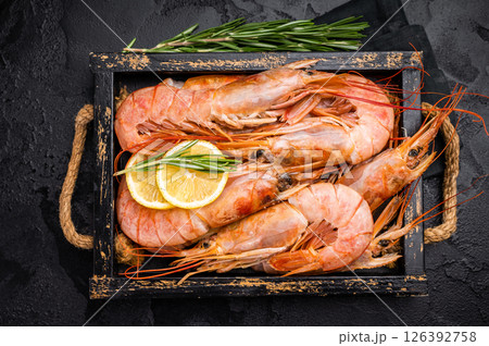Uncooked raw Red shrimps, Prawns Langostino Austral in wooden tray. black background. top view 126392758