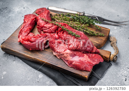 Uncooked Beef Skirt Steak, also name Machete steak, raw meat on cutting board. grey background. top view Uncooked Beef Skirt Steak, also name Machete steak, raw meat on cutting board. grey background. top view 126392780