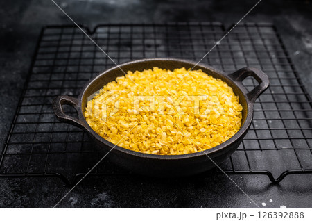 Healthy raw dry Millet flakes for porridge and muesli. black background. top view Healthy raw dry Millet flakes for porridge and muesli. black background. top view 126392888