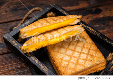 American hot Grilled cheese sandwich in wooden tray. wooden background. top view American hot Grilled cheese sandwich in wooden tray. wooden background. top view 126392905