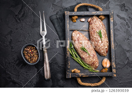 Raw kebabs or kabaps on wooden tray, beautifully arranged and ready to be cooked for a delicious outdoor feast. black background. top view 126393039