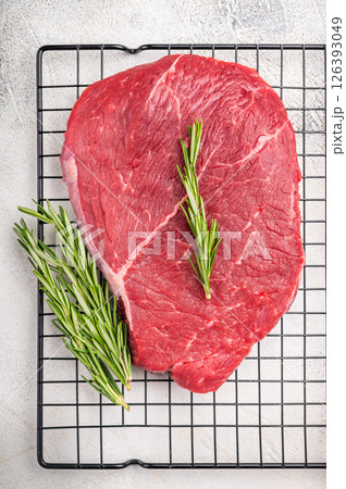 A close up of raw top sirloin beef steak, showcasing its rich color and tender texture, ideal for gourmet cooking. white background. top view 126393049