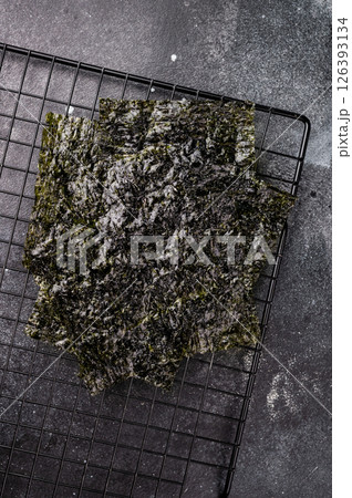 Dried Nori seaweed sheets on a rack. black background. top view 126393134