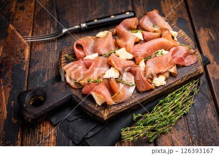 Italian Prosciutto parma ham with herbs and parmesan cheese on wooden board. wooden background. top view Italian Prosciutto parma ham with herbs and parmesan cheese on wooden board. wooden background. top view 126393167