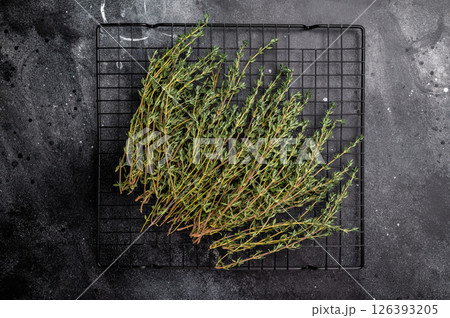 Fresh Herb thyme, sprigs bunch on a rack. black background. top view 126393205