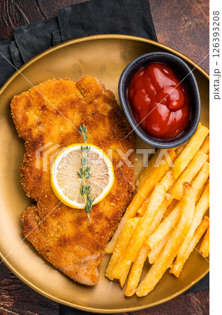 Wiener pork schnitzel steak, breaded meat with french fry on a plate. brown background. top view 126393208