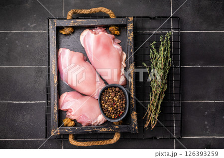 Raw Chicken thighs fillets in a wooden tray. black background. top view Raw Chicken thighs fillets in a wooden tray. black background. top view 126393259