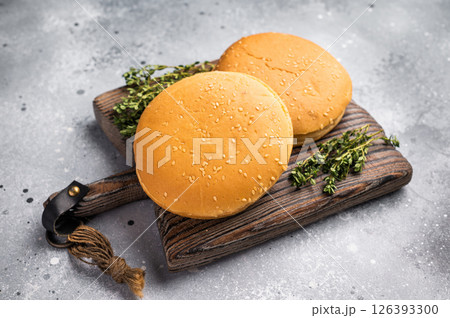 Fresh hamburger buns on wooden board. grey background. top view Fresh hamburger buns on wooden board. grey background. top view 126393300