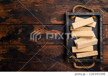 Wafer stick biscuits with vanilla cream in wooden tray. wooden background. top view 126393306