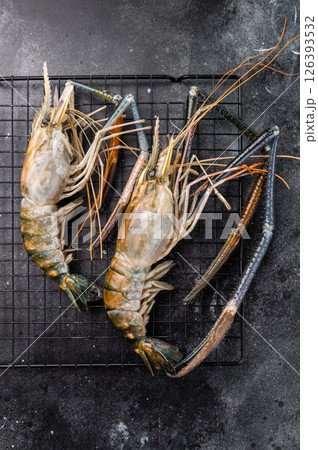 Fresh raw rosenbergii shrimp prawn, perfect for gourmet dishes and seafood lovers seeking premium quality.black background. top view Fresh raw rosenbergii shrimp prawn, perfect for gourmet dishes and seafood lovers seeking premium quality.black background. top view 126393532