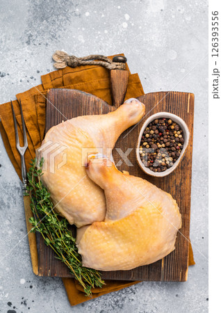 Raw chicken legs on wooden cutting board, eco poultry meat on gray background, top view 126393556