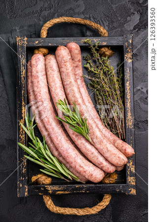 Raw sausage packed with herbs and spices, inviting you to create mouthwatering dishes for any occasion. black background. top view Raw sausage packed with herbs and spices, inviting you to create mouthwatering dishes for any occasion. black background. top view 126393560