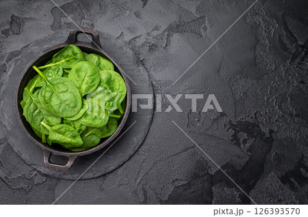 Crisp and lush fresh spinach ready for your favorite recipes, a versatile superfood for every meal. black background. top view Crisp and lush fresh spinach ready for your favorite recipes, a versatile superfood for every meal. black background. top view 126393570