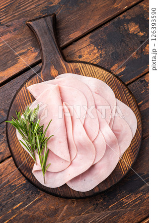 Close up of savory sliced ham showcasing its rich color and texture, a must-have for any deli lover. wooden background. top view 126393590
