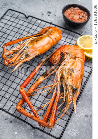 Close up of beautifully grilled rosenbergii prawn, showcasing its smoky glaze and appetizing texture. grey background. top view Close up of beautifully grilled rosenbergii prawn, showcasing its smoky glaze and appetizing texture. grey background. top view 126393606