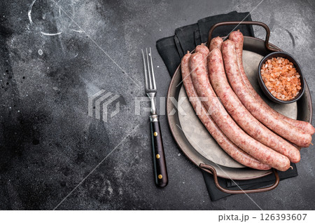 Close up of uncooked raw sausage showcasing its juicy texture, ideal for flavorful dishes and culinary creativity. black background. top view Close up of uncooked raw sausage showcasing its juicy texture, ideal for flavorful dishes and culinary creativity. black background. top view 126393607