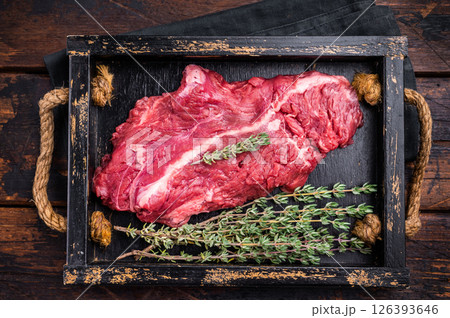 Uncooked hanging tender beef steak, Hanger steak in wooden tray with herbs. wooden background. top view Uncooked hanging tender beef steak, Hanger steak in wooden tray with herbs. wooden background. top view 126393646