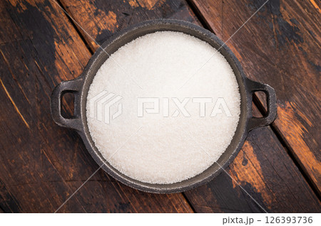 Bright and clean granulated sugar, an essential ingredient for delicious treats and drinks. wooden background. top view Bright and clean granulated sugar, an essential ingredient for delicious treats and drinks. wooden background. top view 126393736