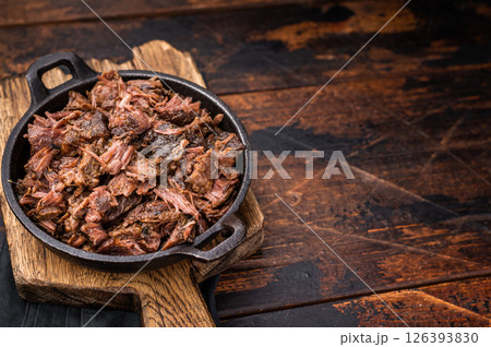 Traditional Barbecue smoked beef meat, pulled beef in a skillet. wooden background. top view Traditional Barbecue smoked beef meat, pulled beef in a skillet. wooden background. top view 126393830